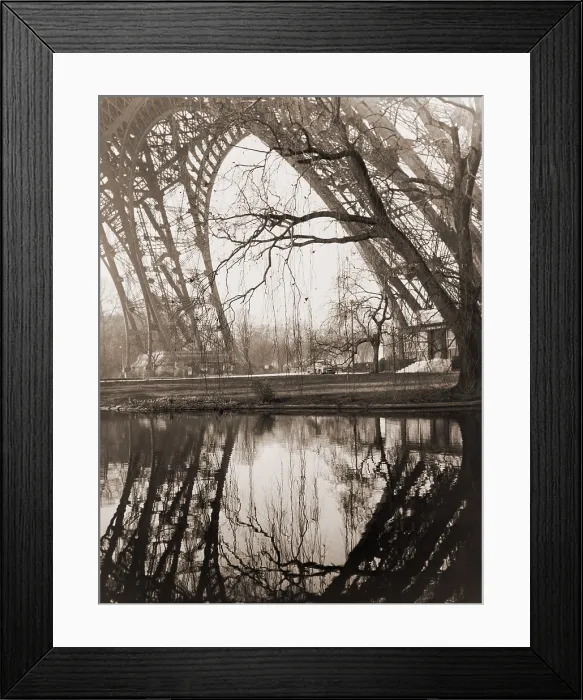 Framed Print : A rare unpopulated winter view of the girders of the Eiffel Tower reflected in the placid waters beneath the tower in Paris. February 1961