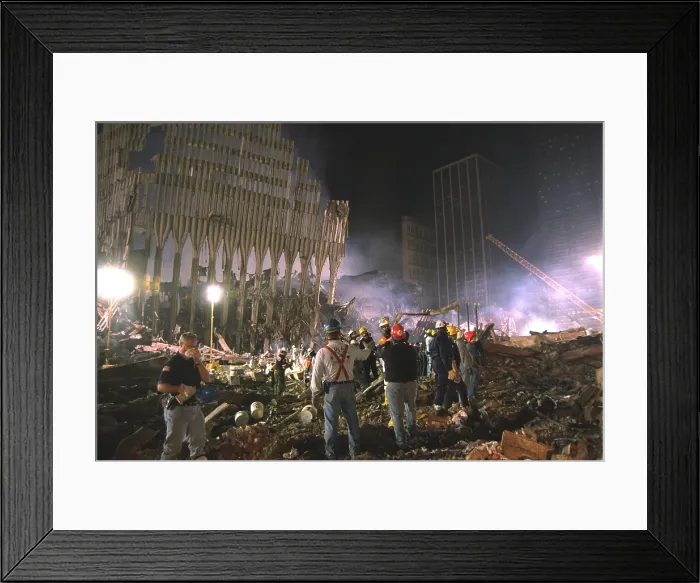 Framed Print : On the south west area of Ground Zero a bucket line removes debris at night, Sept 17, 2001. At left a section of WTC 1, the North Tower still stands
