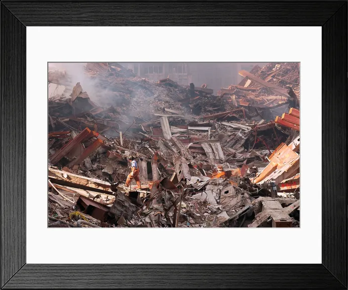 Framed Print : NYC Fire fighter walks over smouldering fires and wreckage at Ground Zero, Sept. 18, 2001. World Trade Center, New York City, after September 11, 2001 terrorist attacks