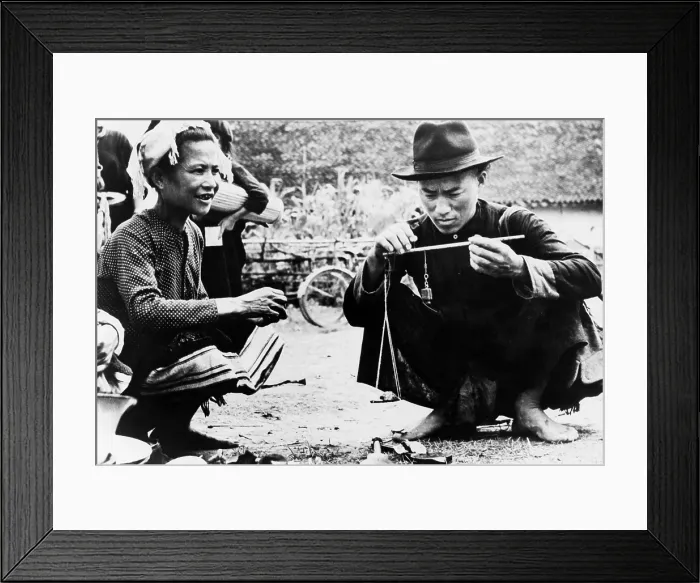 Framed Print : Drug seller openly weighing opium for a customer in an outdoor market in Laos. 1954 Framed Print : Drug seller openly weighing opium for a customer in an outdoor market in Laos. 1954