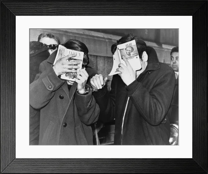 Framed Print : Two New York City students covering their faces with books at police headquarters after they were picked up on narcotics. 1968