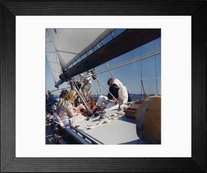 Framed Print : President and Jacqueline Kennedy sailing with her parents, Janet and Hugh Auchincloss. Jackie Kennedy is smoking and reading with the President