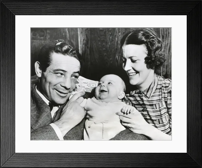 Framed Print : Max Baer with his wife, Mary Ellen Sullivan, and Max Baer Jr. on March 19, 1938. The baby feels Baer's swollen eye, a souvenir of his recent victorious bout with Tommy Farr