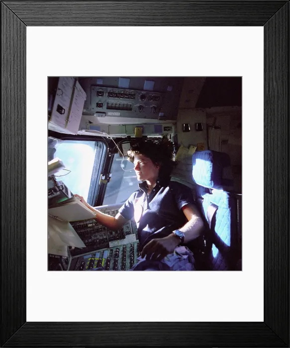 Framed Print : Astronaut Sally Ride monitors control panels from the pilot's chair on the flight deck of the Space Shuttle Challenger. She held her Ph.D