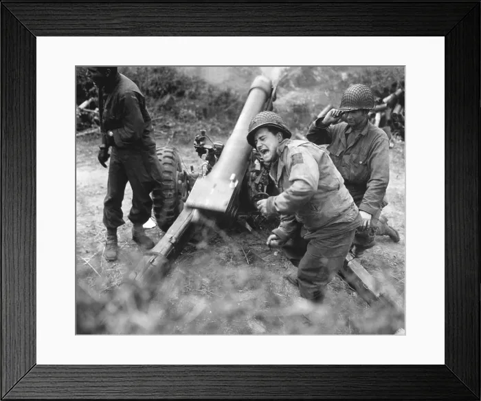 Framed Print : U.S. soldiers fire a 105-mm howitzer during the fighting at Carentan, France. American troops moved inland from Utah and Omaha and linked up at Carentan consolidate the beachhead