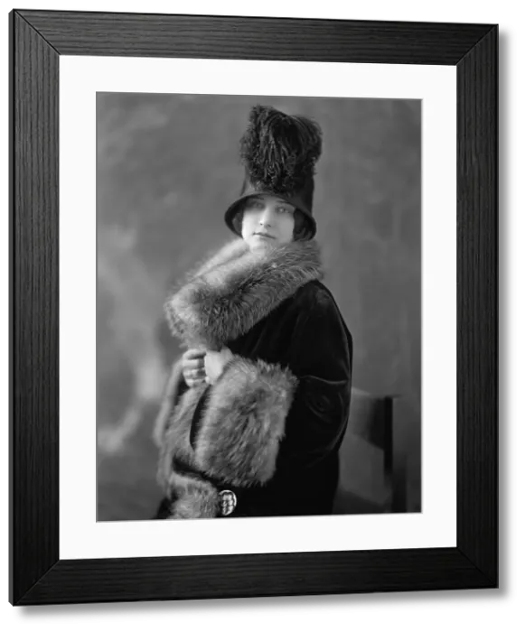 Framed Print : Women wearing fur lined velvet coat with opulent fur collar and cuffs. Her 1920s cloche hat is ornamented with ostrich feathers. (BSLOC_2015_16_243)