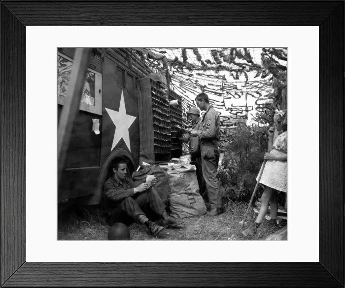 Framed Print : U.S. soldiers sorting mail under a camouflage net in Northern France. A young French girl observes the activity. June-Sept. 1944. World War 2. (BSLOC_2014_2_156)