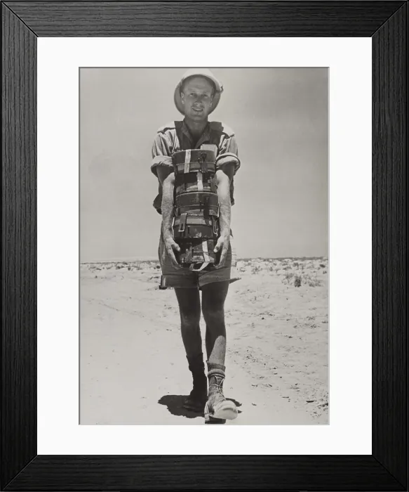 Framed Print : A South African with the British forces in the Western Desert holding a stack of land mines