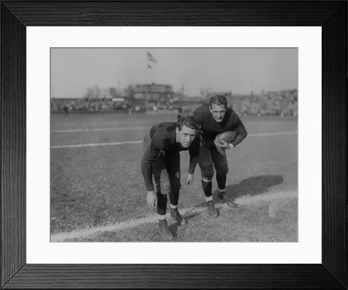 Framed Print : Harold Red Grange (right) and his brother Garland Grange on football field. In the distance are spectators in bleachers. 1929. (BSLOC_2015_17_129)