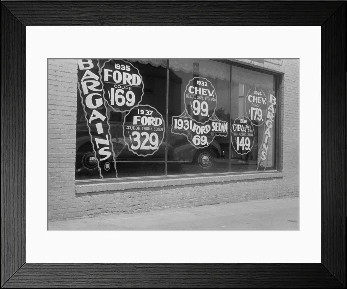Framed Print : In Washington, D.C. a used automobile dealer advertises prices on its showroom window. In Sept. 1939 a 1931 Ford sold for $69, and a 1937 Ford for $329