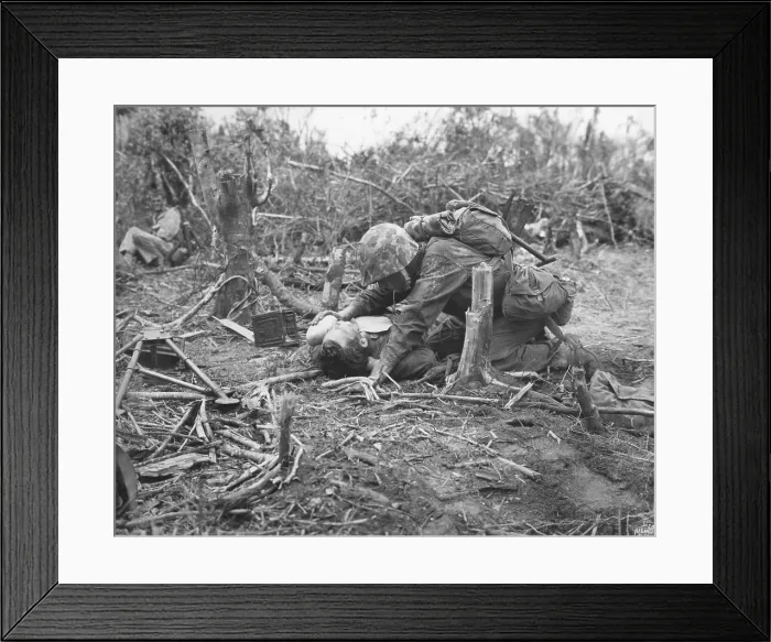 Framed Print : A wounded U.S. Marine takes is given water while waiting for stretcher-bearers to come for him. Peleliu Island. Sept.-Nov. 1944. World War 2, Pacific Ocean. (BSLOC_2013_13_30)
