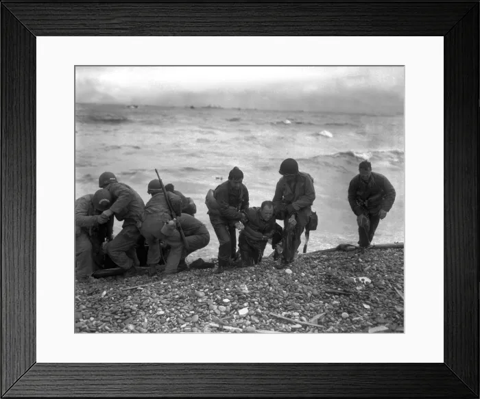 Framed Print : American soldiers help others whose landing craft was sunk off Utah Beach on D-Day. The survivors reached the beach of Cherbourg by using a life raft. June 6, 1944, World War 2