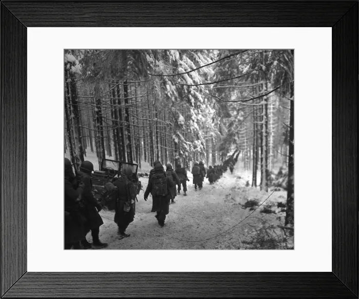 Framed Print : U.S. soldiers march along the snow-covered road in the Battle of the Bulge. They were advancing to block retreating German army by cutting off the St