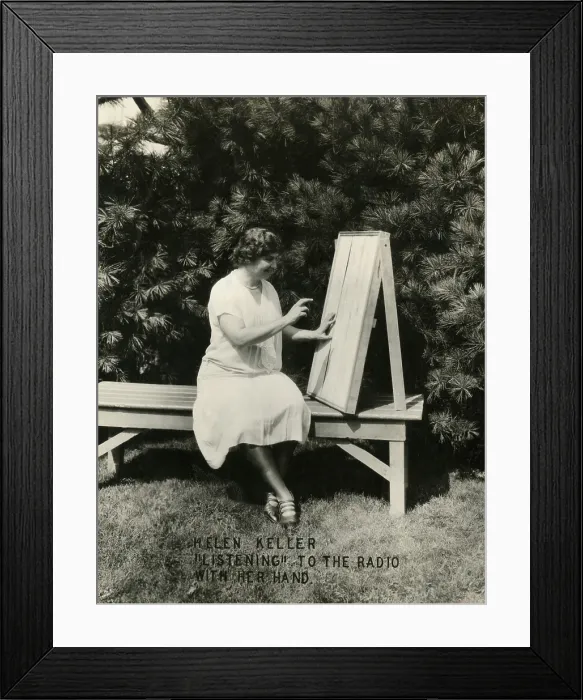 Framed Print : Helen Keller listening to the radio with her hand