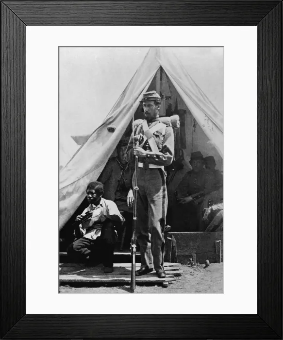 Framed Print : A New York State soldier poses before his tent at Camp Cameron holding his bayoneted rifle with an African American contraband boy shining shoes at his side