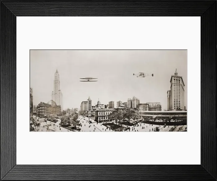 Framed Print : Wide angle panorama with two airplanes in flight over downtown Manhattan. At left are the Custom House and Woolworth Building in center is City Hall and at left Park Place Framed Print : Wide angle panorama with two airplanes in flight over downtown Manhattan. At left are the Custom House and Woolworth Building in center is City Hall and at left Park Place