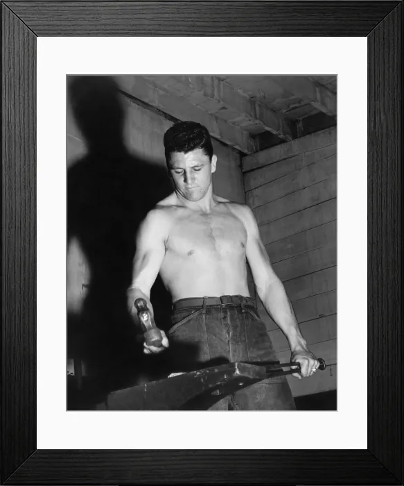 Framed Print : CCC enrollee forging a piece of steel in a CCC blacksmith shop. 1930s. (BSLOC_2013_8_21)