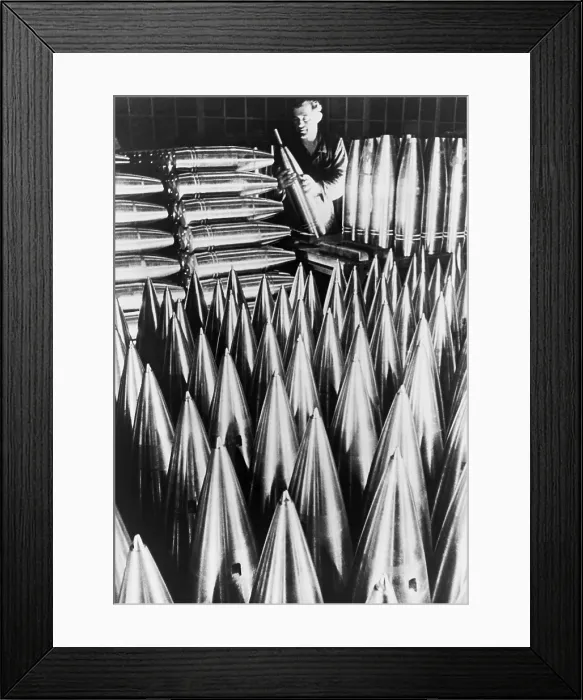 Framed Print : German munitions worker inspecting large shell casings. Ca. 1939-40. World War 2. (BSLOC_2014_10_158)