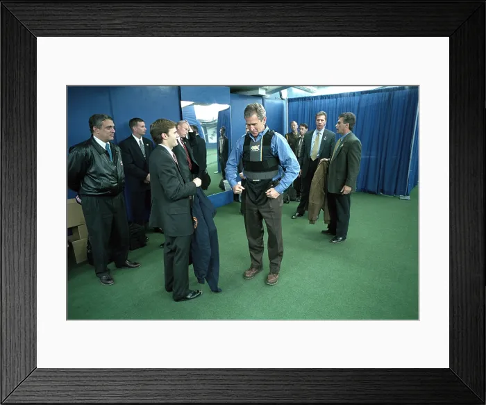 Framed Print : President George W. Bush puts on a vest before the first pitch in Game 3 of the World Series. At left is CIA Director, George Tenet. (BSLOC_2015_2_180)