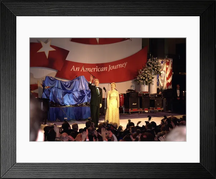Framed Print : First Lady Hillary Clinton wearing an Oscar de la Renta evening gown at a 1997 Inaugural Ball. President Bill Clinton waves to the crowd beyond the press photographers. Jan