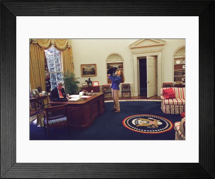 Framed Print : Chelsea Clinton Playing with Socks the Cat in the Oval Office. At left, President Bill Clinton Works at his desk. Dec. 24, 1994. (BSLOC_2015_2_201)