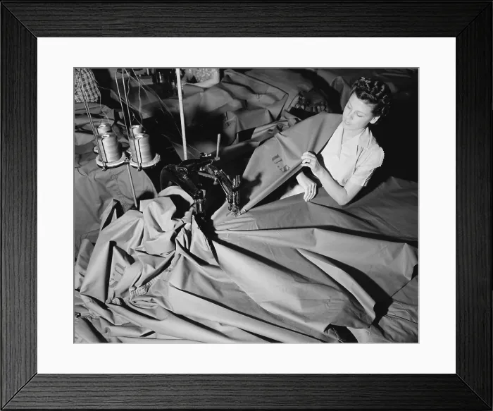 Framed Print : A young woman sews pup tents for the U.S. Army. At the Langdon Tent & Awning Company, a two-needle machine joins widths of cloth to form the tent. June 1941