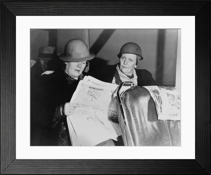 Framed Print : After working all night, two helmeted women shipyard workers read the newspaper on the bus home. Ca. 1940-45. World War 2. (BSLOC_2014_10_216)