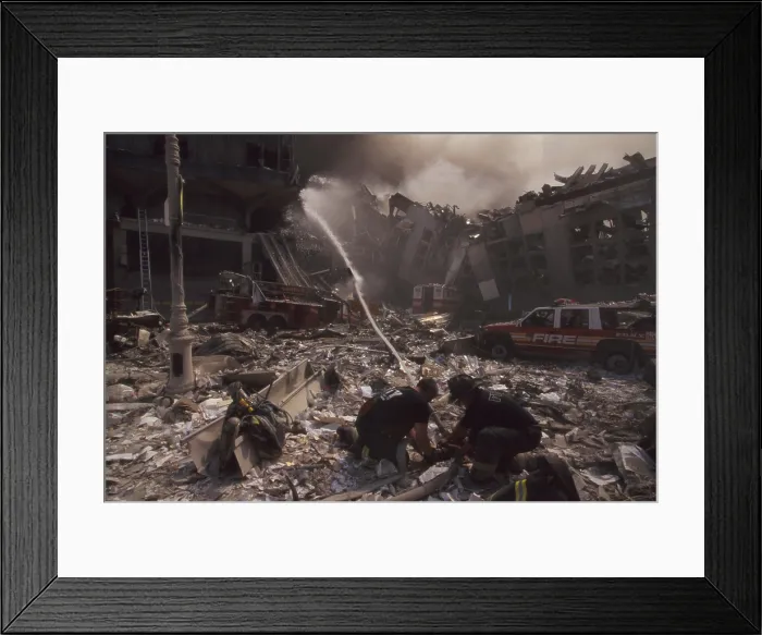 Framed Print : Fire fighters set up a hose amid smoking rubble following September 11th terrorist attack on World Trade Center. At left is still standing WTC 6