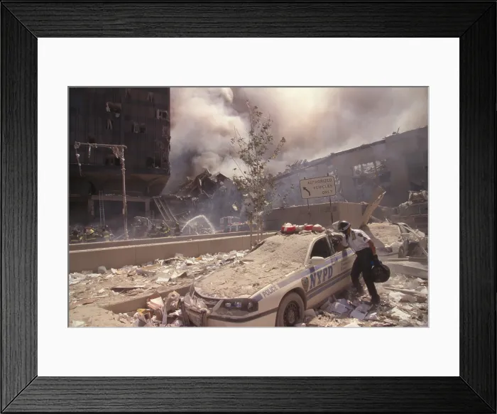 Framed Print : Policeman reaching into a debris covered police car after 9-11 terrorist attack in NYC. At left is still standing WTC 6 Framed Print : Policeman reaching into a debris covered police car after 9-11 terrorist attack in NYC. At left is still standing WTC 6