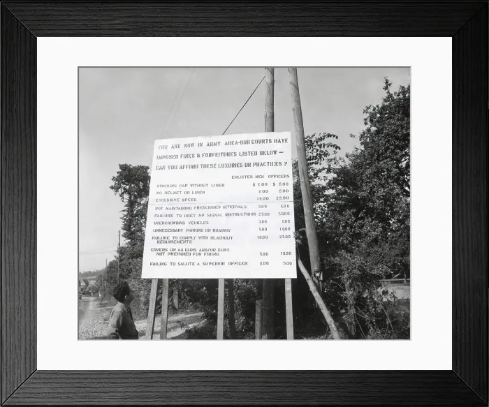 Framed Print : U.S. soldier reads table of crimes and fines for misconduct in Normandy