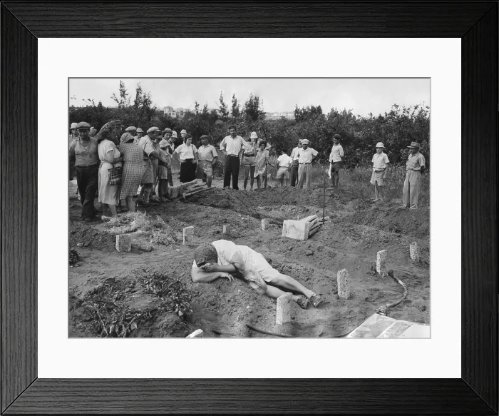 Framed Print : A grief stricken mother lying on the grave of her Haganah soldier son. Near Tel Aviv, July 31, 1948