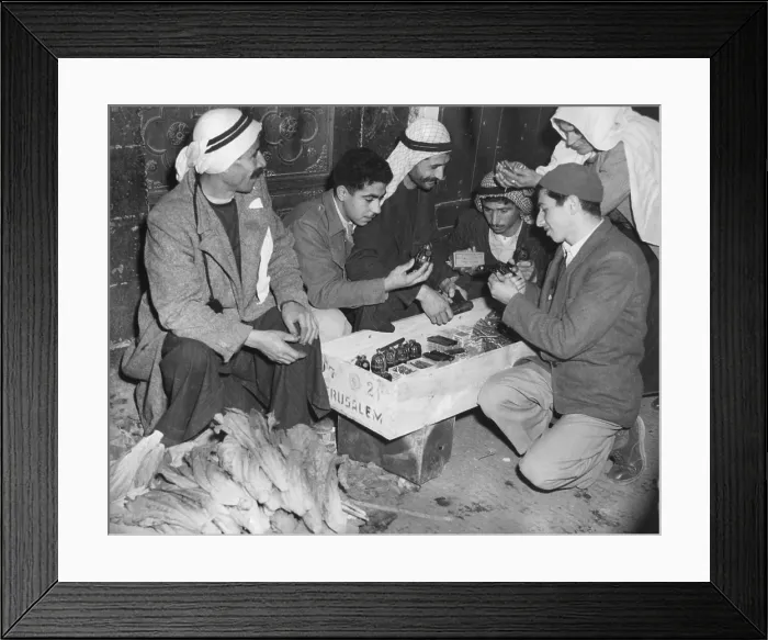 Framed Print : Arab Palestinians examine weapons in a Jerusalem market. Guns, bullets, and hand grenades were for sale beside vegetables on March 1, 1948. - (BSLOC_2014_15_202)