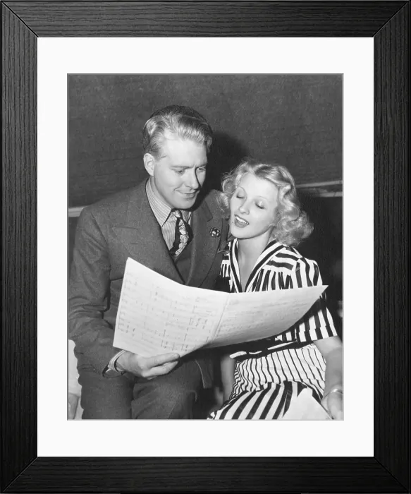Framed Print : BALALAIKA, from left: Nelson Eddy, Ilona Massey studying a music score on set, 1939