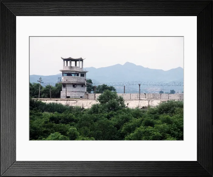 Framed Print : North Korean guard tower decorated with a Communist red star on the wall and barbed wire separating South Korea from North Korea