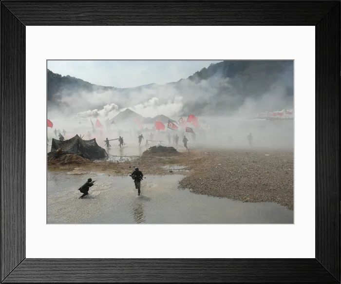 Framed Print : South Korean soldiers dressed as North Korean infantry charge South Korean defenses at the re-enactment of the Nakdong River Battle during the 60th anniversary commemoration of