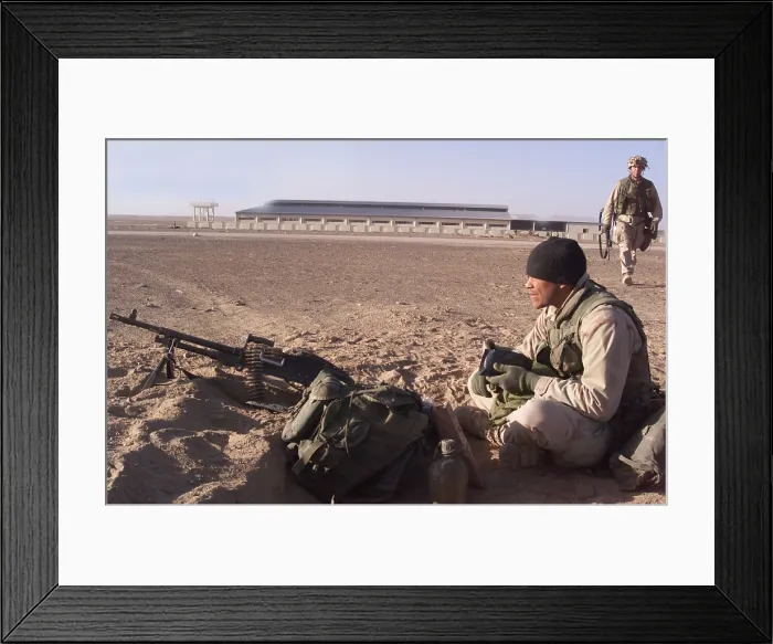 Framed Print : An Special Operations infantryman takes bite to eat while scanning the Afghan desert for enemy forces after the seizure of a forward operating base on Nov. 26 2001 as U.S
