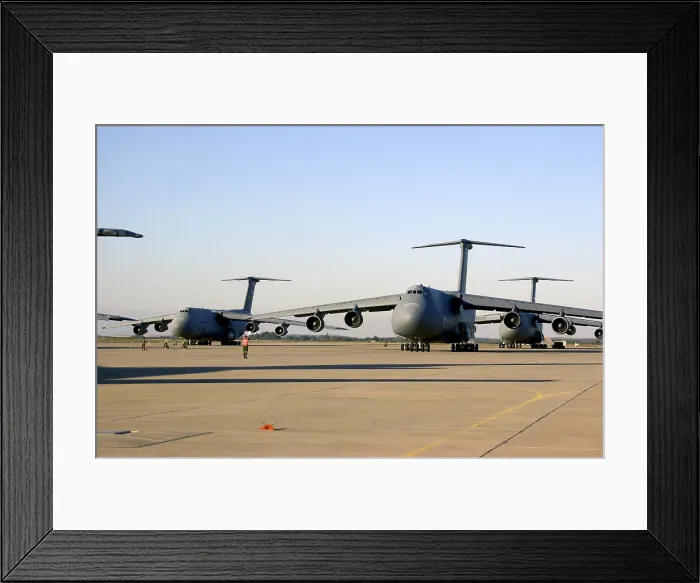 Framed Print : An U.S. airman dwarfed by a C-5 Galaxy cargo aircraft signals the plane through a crowded runway at Moron Air Base Spain Framed Print : An U.S. airman dwarfed by a C-5 Galaxy cargo aircraft signals the plane through a crowded runway at Moron Air Base Spain