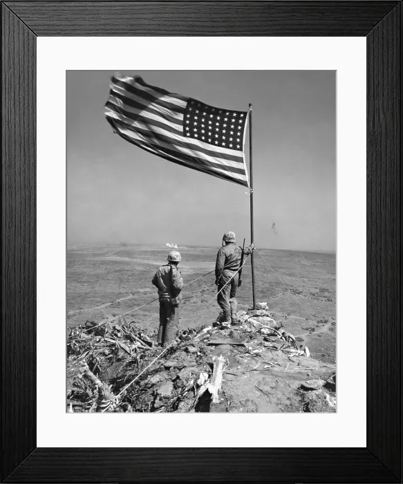 Framed Print : Stars and Stripes wave over the summit of Mt. Suribachi on Iwo Jima. Two Marines gaze at remainder of island, part of which is stubbornly held by Japanese. On or after Feb