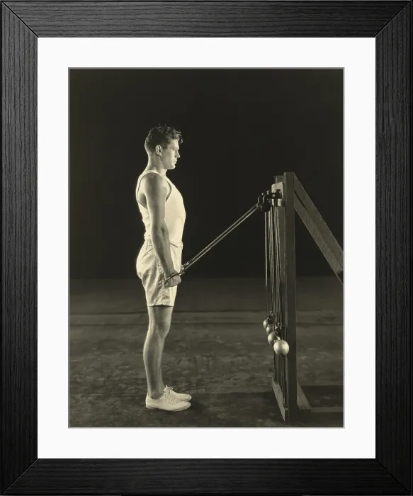 Framed Print : Gene Tunney, World Heavy Weight Champion lifting weights on pulleys. Ca. 1926. (BSLOC_2015_14_214)