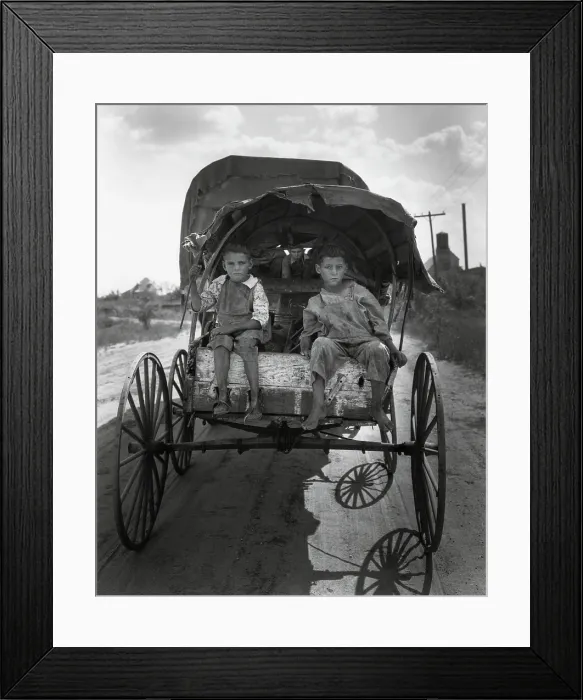 Framed Print : Barefoot children of migrant cotton pickers looking for work in Texas, Sept. 1931. Two boys sit on the back of a metal wheeled covered wagon pulled by another vehicle Framed Print : Barefoot children of migrant cotton pickers looking for work in Texas, Sept. 1931. Two boys sit on the back of a metal wheeled covered wagon pulled by another vehicle