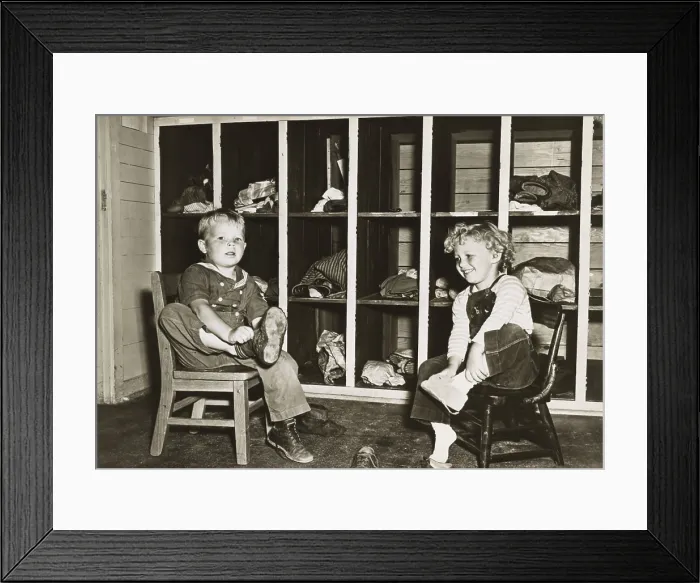 Framed Print : Children take off their shoes before a nap in a public nursery during World War 2 Framed Print : Children take off their shoes before a nap in a public nursery during World War 2