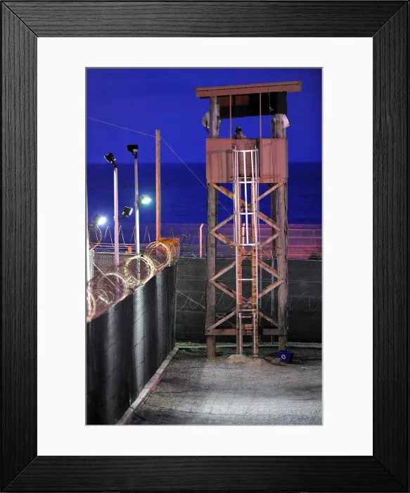 Framed Print : U.S. Soldier stands watch in a guard tower at Camp Delta in Guantanamo Bay Naval Base Cuba. July 7 2010. Photo by:Everett Collection(BSLOC_2011_6_167)
