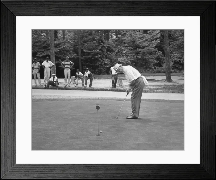 Framed Print : President Dwight Eisenhower on a putting green of a golf course. August 1957. African American caddies watch from the distance. - (BSLOC_2014_16_100) Framed Print : President Dwight Eisenhower on a putting green of a golf course. August 1957. African American caddies watch from the distance. - (BSLOC_2014_16_100)