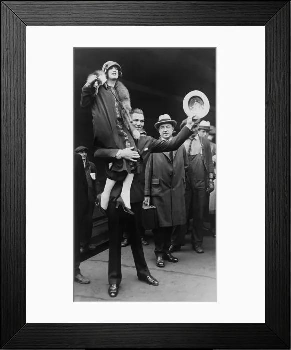 Framed Print : Boxer Jack Dempsey in Chicago, hoisting his bride, Estelle Taylor, on his right shoulder. April 22, 1925. The movie actress was his second wife. (BSLOC_2015_17_74)