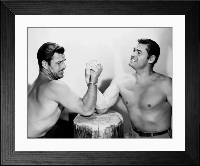 Framed Print : SWAMP FIRE, action costars (from left) Buster Crabbe, Johnny Weissmuller, arm-wrestling on-set, 1946