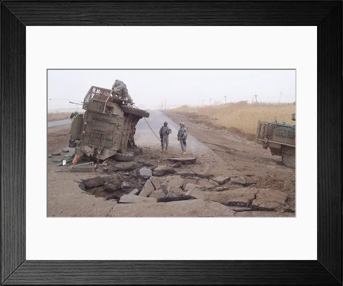Framed Print : Stryker vehicle lies on its side after surviving a IED blast in 2007
