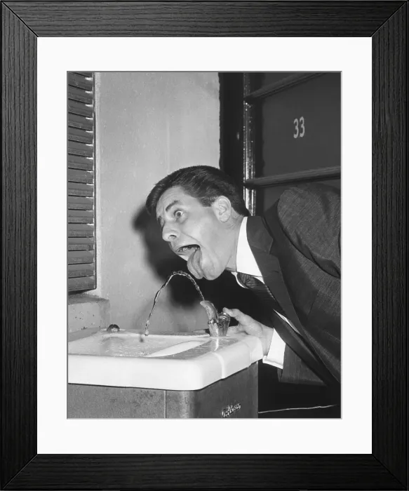 Framed Print : Jerry Lewis providing White House Photographer, Abbie Rowe, with a comic image at water fountain. July 25, 1957. - (BSLOC_2014_16_167) Framed Print : Jerry Lewis providing White House Photographer, Abbie Rowe, with a comic image at water fountain. July 25, 1957. - (BSLOC_2014_16_167)