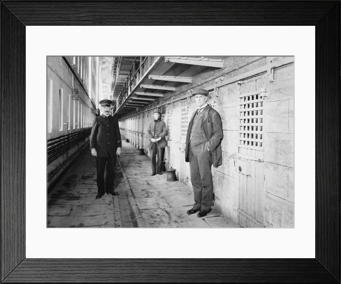 Framed Print : Thomas Mott Osborne (at right), Warden of Sing Sing prison in a cell block with guards