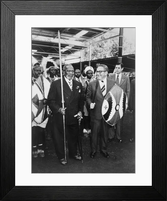 Framed Print : Henry Kissinger, standing with President Jomo Kenyatta, in Nairobi, Kenya, 1976. Kissinger holds a shield and sword, while Kenyatta has a pike. April 27, 1976. (BSLOC_2015_14_50) Framed Print : Henry Kissinger, standing with President Jomo Kenyatta, in Nairobi, Kenya, 1976. Kissinger holds a shield and sword, while Kenyatta has a pike. April 27, 1976. (BSLOC_2015_14_50)