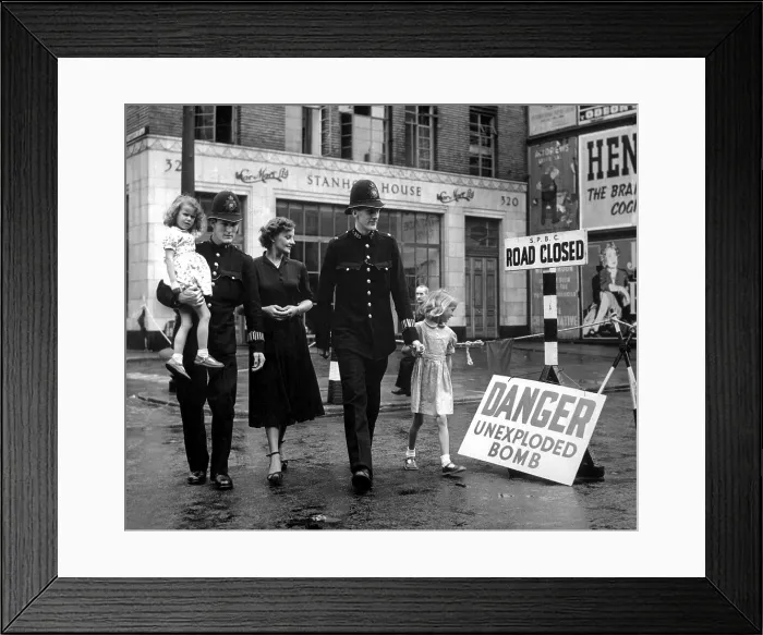 Framed Print : A family is escorted away from the site of an unexploded German bomb in 1948. A 2, 500 pound German bomb, buried opposite University College Hospital, London, fell in 1941